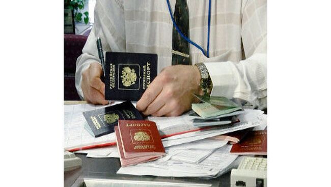 Сотрудник посольства проверяет паспорта российских граждан