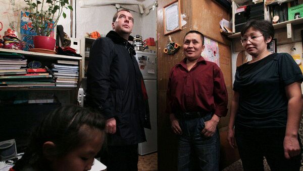 Президент России Дмитрий Медведев (слева) во время осмотра ветхой квартиры, где живет семья Николаевых
