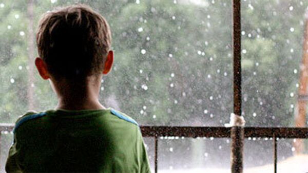 Ребенок смотрит в окно. Архивное фото