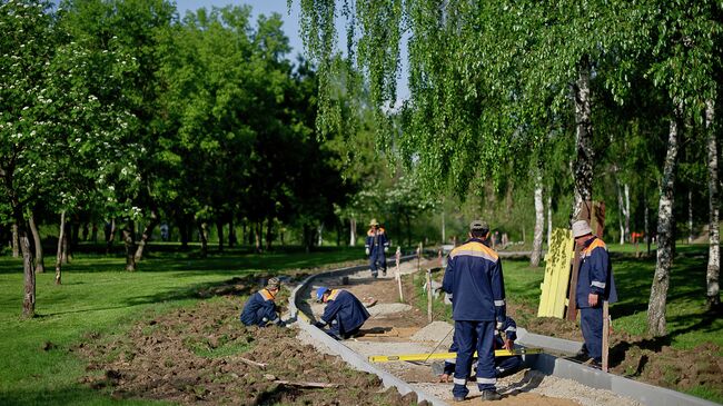 Рабочие возводят пешеходную дорожку в парке. Архив