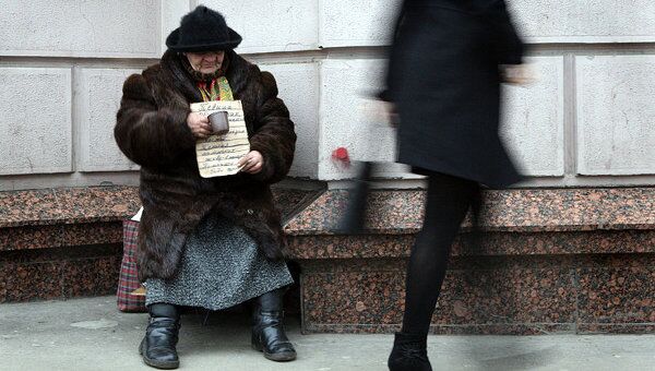 Женщина просит милостыню на одной из улиц Москвы