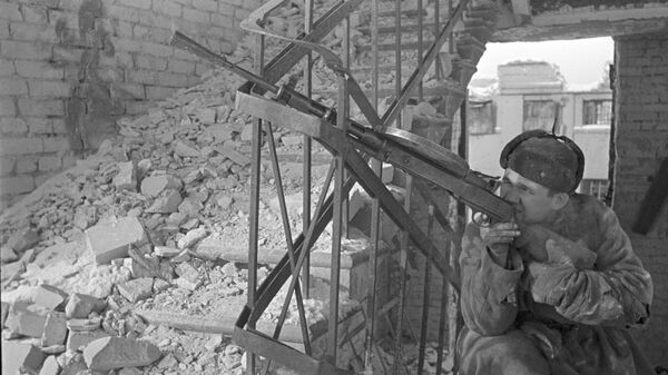 Боец стреляет из ручного пулемета на лестничной клетке разрушенного дома. Битва за Сталинград