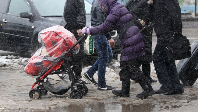 Пешеходы переходят дорогу по лужам