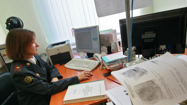 Сотрудник УВД ЗАО города Москвы работает с отпечатками пальцев в отделе криминалистик