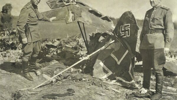 Сотрудник ТГУ В.Майский (слева) у сбитого немецкого самолета, 1944 г.