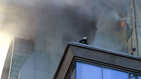 Пламя вырывалось сквозь стены бизнес-центра, охваченного огнем 
