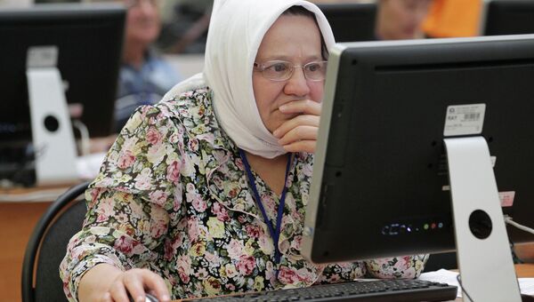 Пенсионерка работает за компьютером. Архив
