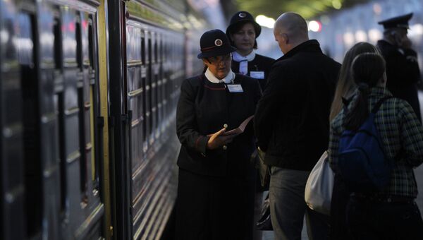 Проводница проверяет билеты у пассажира поезда. Архив
