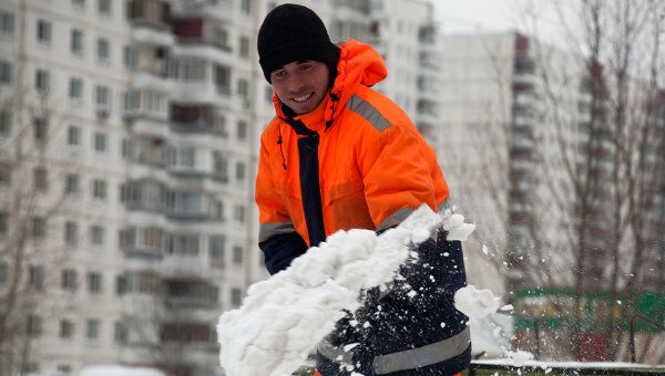 Дворник расчищает снег на одной из улиц Москвы. Архив