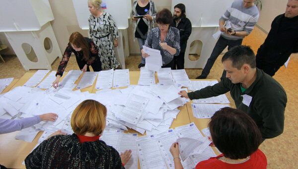 Члены участковой избирательной комиссии пересчитывают бюллетени после окончания выборов депутатов Государственной Думы РФ шестого созыва