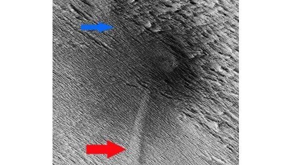 Саблевидная дюна (отмечена стрелками), образовавшаяся в результате столкновения ударной волны при падении метеора с почвой Марса