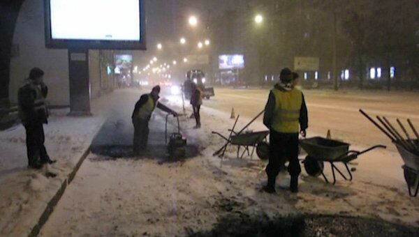 Московские рабочие укладывали асфальт во время снегопада