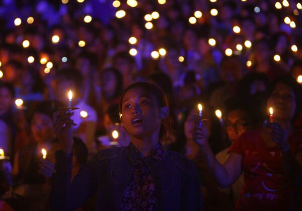 Индонезийские христиане держать свечи во время молитвы в канун Рождества в Джакарте