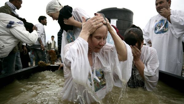 Православные паломники совершают омовение в купелях, наполненных водой из Иордана