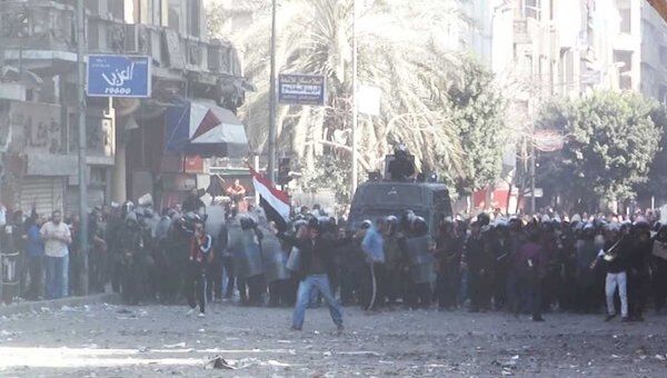 Демонстранты забрасывают полицейских камнями у здания МВД в Каире  