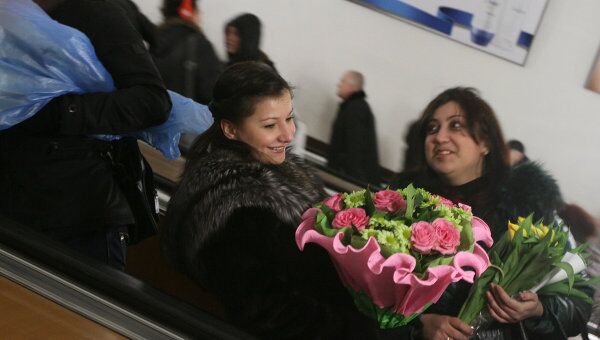 Девушки с букетами цветов на эскалаторе