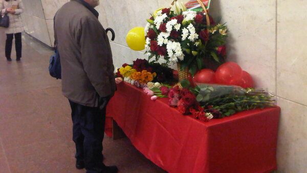 Люди приносят цветы в память о погибших при взрывах в московском метро. Станция Лубянка