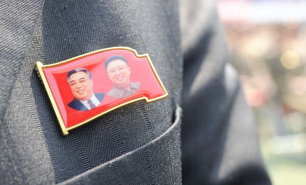 Значок на груди участника торжественного собрания военнослужащих Народной армии КНДР