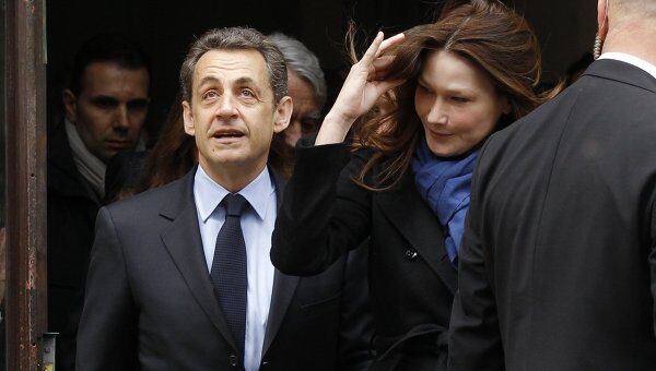 Николя Саркози с супругой покидают избирательный участок