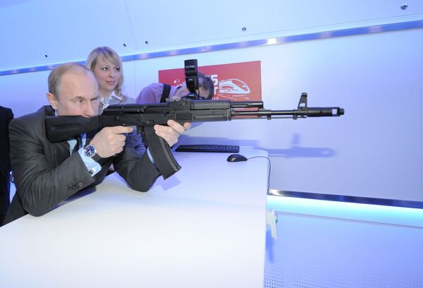 Владимир Путин с помощью макета автомата АК-74 стреляет в мишень в электронном тире
