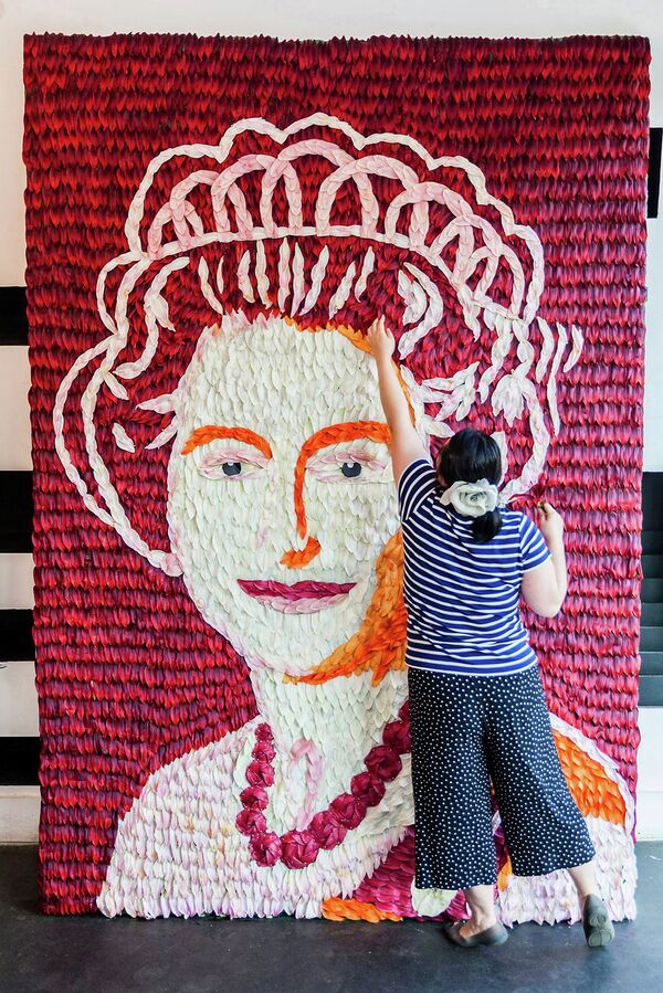 Флорист работает над стендом с изображением королевы Елизаветы II
