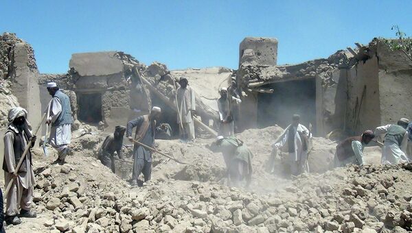 Жители Афганистана разгребают завалы на месте авиаудара НАТО в провинции Логар
