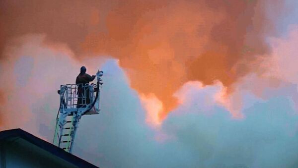 Клубы белого дыма поднимались над горящим мебельным складом в Москве