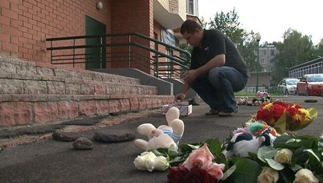 Люди несут цветы и игрушки к дому, где дети были сброшены с 15 этажа