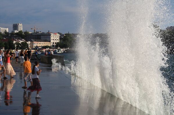 Купание в волнах на набережной Севастополя. Знойная летняя 