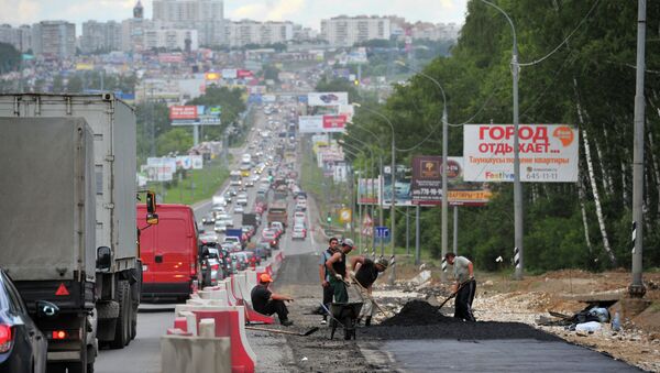 Работники дорожно-ремонтной службы укладывают асфальт на Калужском шоссе. Архивное фото