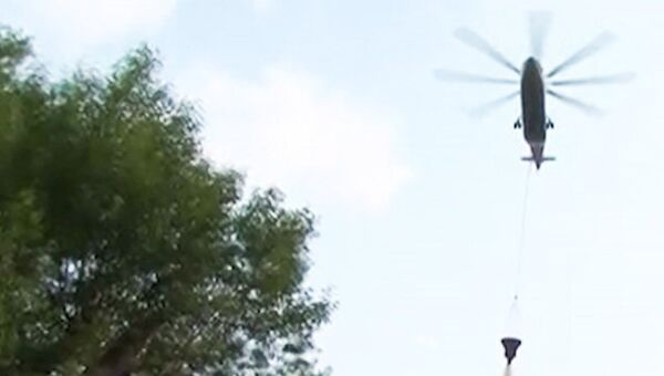 Вертолеты сбрасывают воду на горящий ангар в Москве