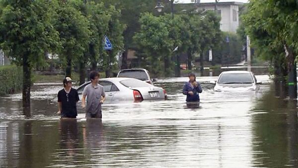 Японцы ходят по улицам затопленных городов по пояс в воде