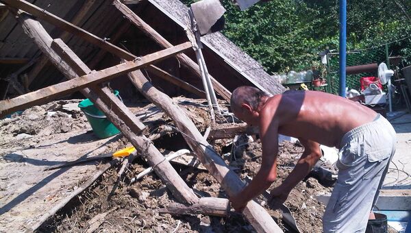 Житель хутора Верхнеадагум Виталий Торопков разбирает развалины своего дома