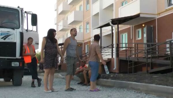 Жители разрушенных домов Крымска осматривают свои новые квартиры