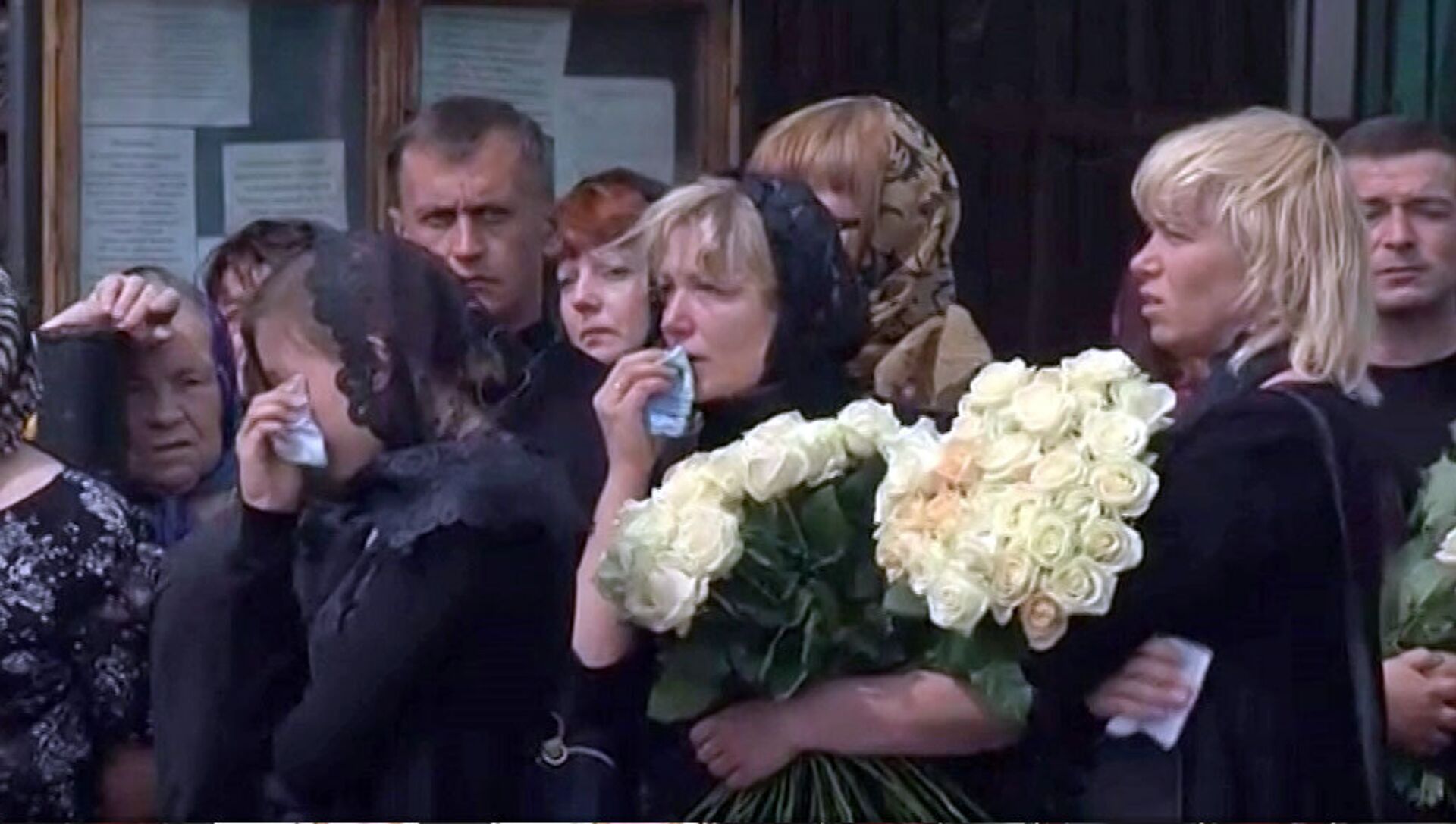Женщина плачет на похоронах