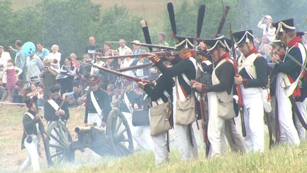 Реконструкторы в мундирах русской армии 1812 года палят из кремневых ружей