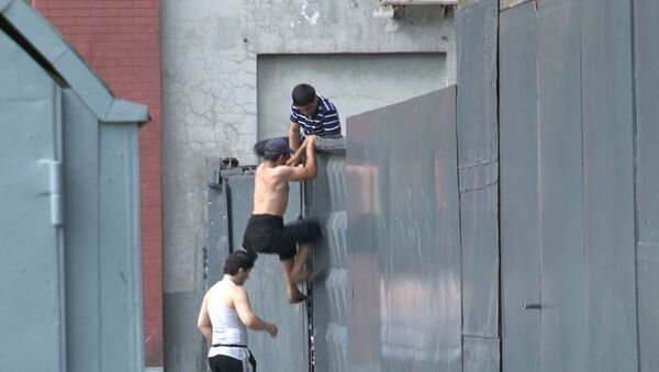Нелегалы перепрыгивают через забор, убегая от сотрудников ФМС 