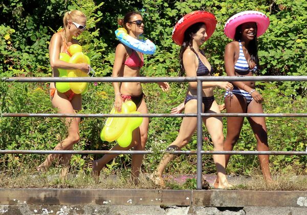 Женщины в купальниках прогуливаются вдоль реки Лиммат в Цюрихе