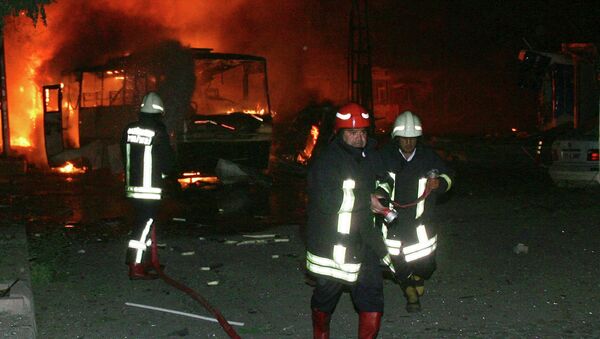 Пожарные заливают водой искореженные взрывом в Турции автомобили 