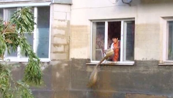 Люди ведрами вычерпывают воду из домов после наводнения на Кубани