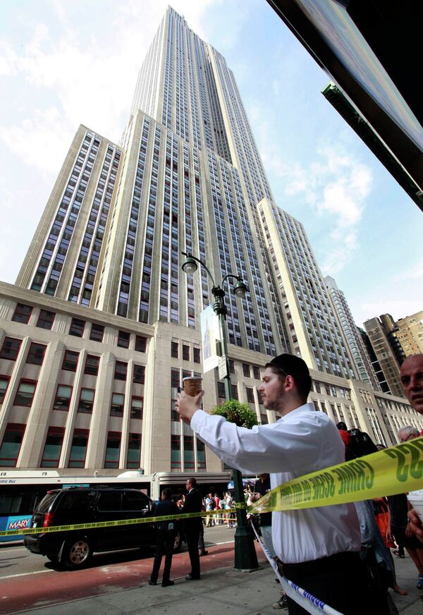 Прохожие стоят возле Empire State Building, где произошла перестрелка