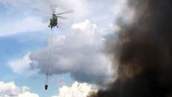 Вертолет сбрасывает тонны воды на горящий склад в Подмосковье