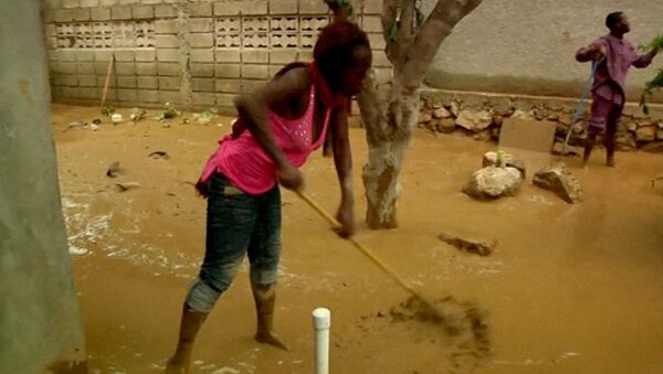 Жители Гаити вычерпывают воду и грязь после шторма Исаак