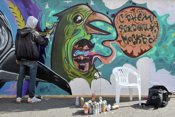 Молодой человек рисует граффити