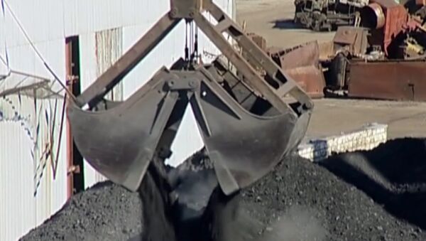 Уголь с помощью гигантских ковшей разгружают к зиме в порту Магадана 