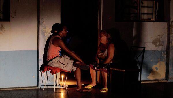 Кубинцы сидят около своих домов во время отключения электричества в Гаване
