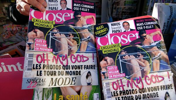 Мужчина держит французский журнал Closer, который опубликовал пикантные фотографии герцогини Кембриджской Кейт