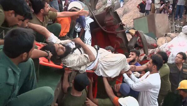 Спасатели вытаскивают людей на месте крушения двух поездов в Пакистане