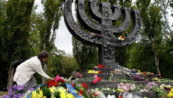 Женщина кладет цветы к монументу памяти жертв трагедии Бабьего Яра