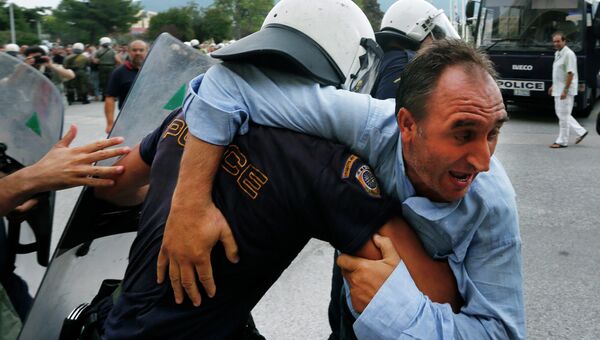Греческий полицейский и участник акции протеста в Афинах